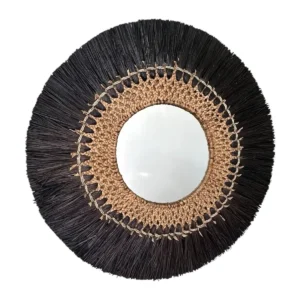 Round wall mirror with woven natural fiber center and black grass fringe frame.