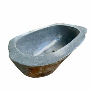 Natural riverstone bathtub handcrafted from a single stone, featuring a smooth interior and rustic outer surface.