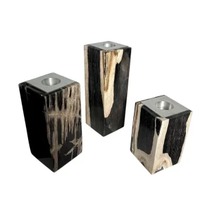 Set of three handmade petrified wood candle holders with polished fossil surfaces and metal inserts.